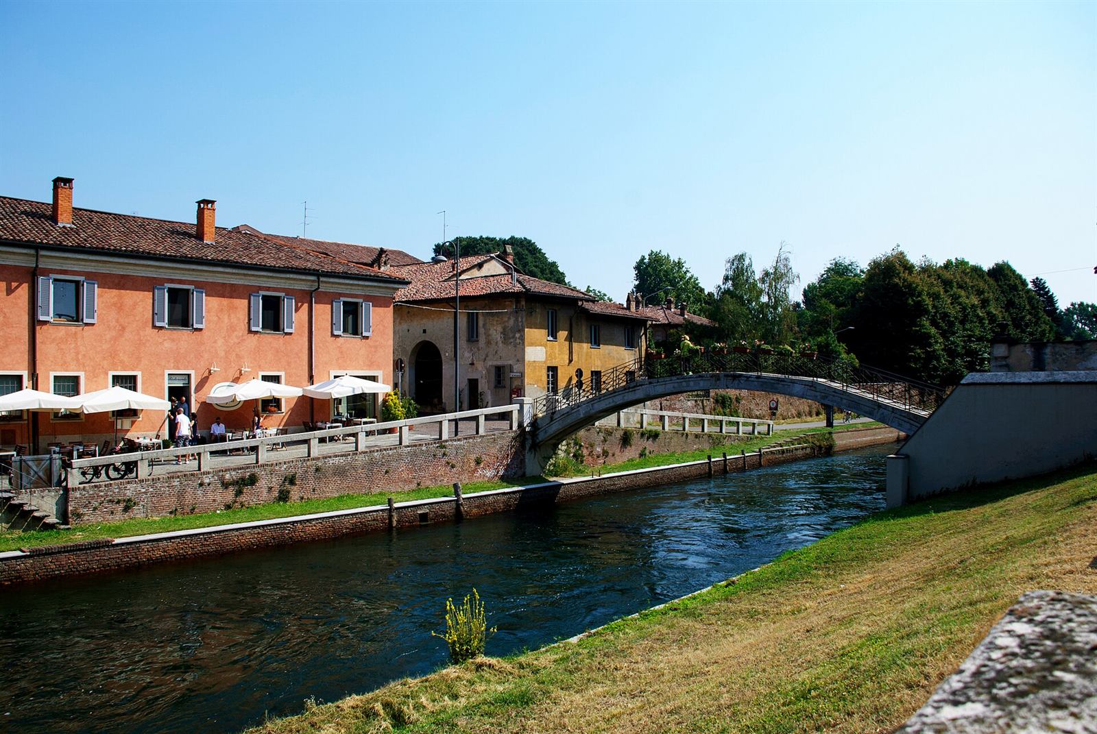 Campagna della pianura a ovest di Milano: campi coltivati, una strada di campagna e una cascina con filari di pioppi all'orizzonte