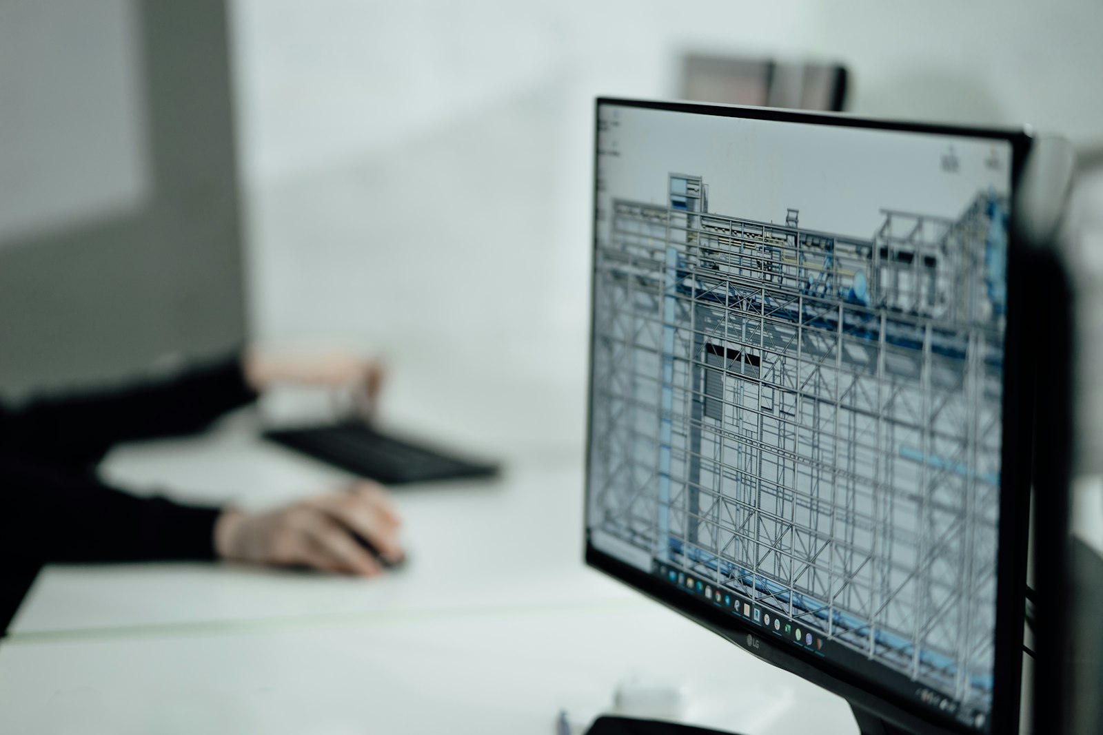 Postazione di lavoro tecnica con monitor che mostra il modello tridimensionale di una struttura